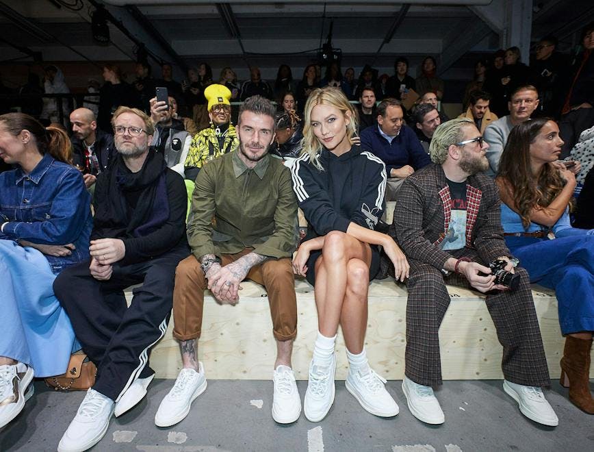 clothing apparel shoe footwear person human sitting crowd