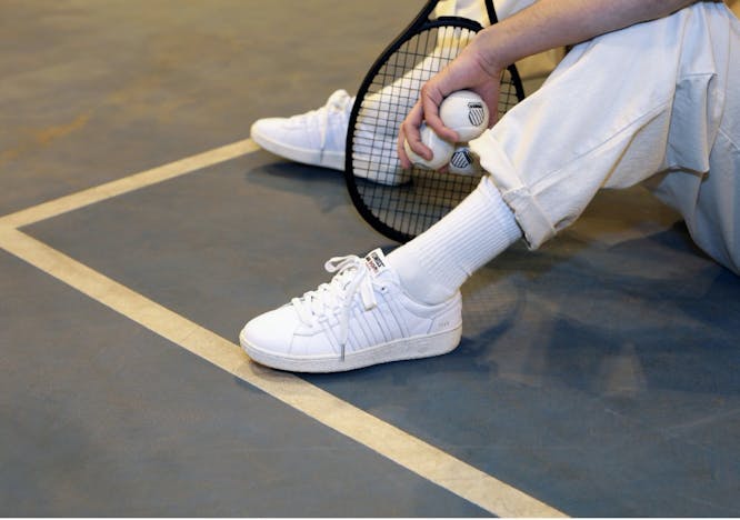 shoe clothing footwear apparel person human tennis racket racket sneaker