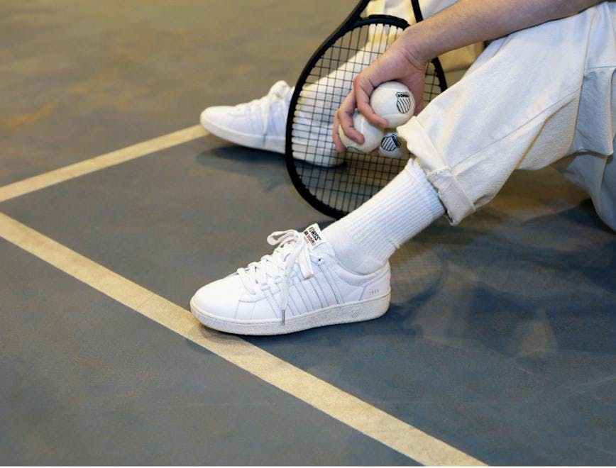 shoe clothing footwear apparel person human tennis racket racket sneaker